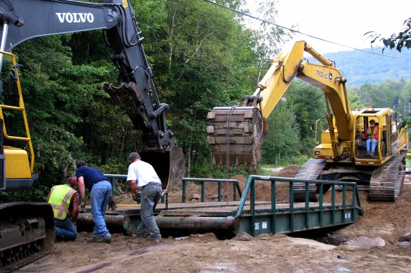 While installing a temporary bridge on Saturday morning at the Bean Brook washout on Swain Road, Rumford Public Works crewman Troy Duguay (left}, Mike Miller and Jim Nicols of Nicols Bros. Logging Inc. of Rumford check the alignment of bridge parts. While installing a temporary bridge on Saturday morning at the Bean Brook washout on Swain Road, Rumford Public Works crewman Troy Duguay (left}, Mike Miller and Jim Nicols of Nicols Bros. Logging Inc. of Rumford check the alignment of bridge parts.