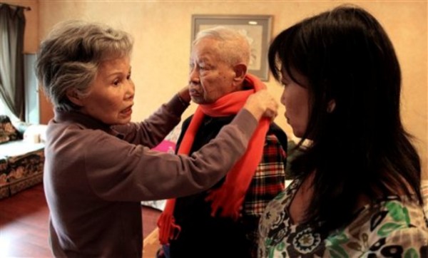 Shou-Mei Li, left, wraps a scarf around her husband Hsien-Wen Li, who is an Alzheimer's patient, as their daughter Shirley Rexrode, right, looks on, at their home in San Francisco.
Shou-Mei Li, left, wraps a scarf around her husband Hsien-Wen Li, who is an Alzheimer's patient, as their daughter Shirley Rexrode, right, looks on, at their home in San Francisco.