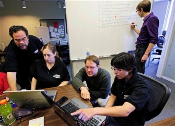 Aspiritech co-founder Moshe Weitzberg, standing left, works with employees, from left, Katie Levin, Rick Alexander and Jamie Specht, at the nonprofit enterprise that specializes in finding software bugs as they test a new program in Highland Park, Ill. Marc Lazar, Aspertech's autism specialist works in the background. Aspiritech co-founder Moshe Weitzberg, standing left, works with employees, from left, Katie Levin, Rick Alexander and Jamie Specht, at the nonprofit enterprise that specializes in finding software bugs as they test a new program in Highland Park, Ill. Marc Lazar, Aspertech's autism specialist works in the background.