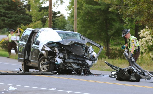 Penobscot Sheriff Deputy William Birch pulls debris from the ditch and piles it next to one of two vans that were involved in a head-on collision on Route 9 in Eddington on Thursday, September 1, 2011. Penobscot Sheriff Deputy William Birch pulls debris from the ditch and piles it next to one of two vans that were involved in a head-on collision on Route 9 in Eddington on Thursday, September 1, 2011.