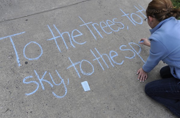 Student Amanda Mayette of Readfield writes a verse of the University of Maine's "Maine Stein Song" on the sidewalk to the Folger Library on Wednesday afternoon after joining fellow honor society members in singing that song there. Student Amanda Mayette of Readfield writes a verse of the University of Maine's "Maine Stein Song" on the sidewalk to the Folger Library on Wednesday afternoon after joining fellow honor society members in singing that song there.