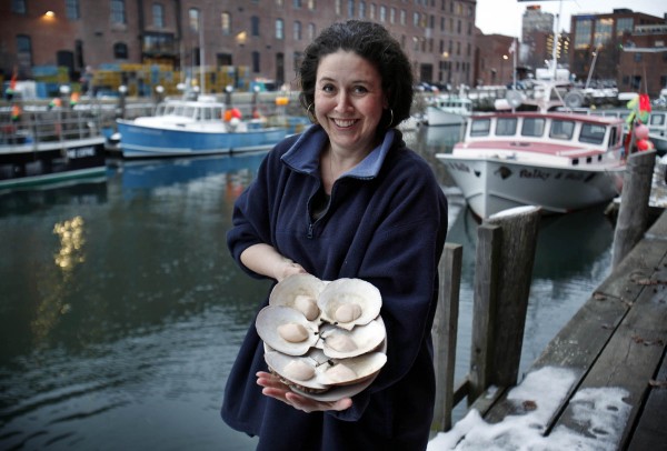 Togue Brawn poses with a plate of scallops on the half shell in Portland, Maine. Togue Brawn poses with a plate of scallops on the half shell in Portland, Maine.