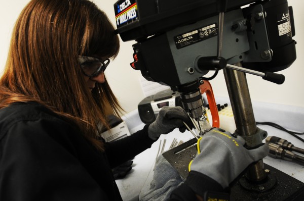 Betsy Emery uses a drill press on Tuesday, Feb. 14, 2012, to make holes in gas tubes used on the small arms that MGI maunfactures at their Old Town facility. Betsy Emery uses a drill press on Tuesday, Feb. 14, 2012, to make holes in gas tubes used on the small arms that MGI maunfactures at their Old Town facility.