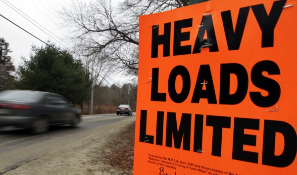Cars pass a sign posted along a road prohibiting heavy trucks to use it in Brunswick on Wednesday, March 14, 2012. Hundreds of miles of roads are posted as the spring thaw comes early to northern New England. Cars pass a sign posted along a road prohibiting heavy trucks to use it in Brunswick on Wednesday, March 14, 2012. Hundreds of miles of roads are posted as the spring thaw comes early to northern New England.