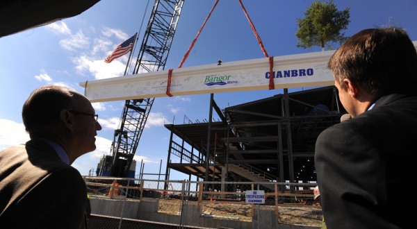 Cianbro Corp. CEO Peter Vigue and Bangor City Council Chairman Cary Weston look on as a ceremonial steel beam is lifted into place on the new Bangor Arena. The beam had a tree and an American flag attached — the traditional marks used by builders when topping off a structure. Cianbro Corp. CEO Peter Vigue and Bangor City Council Chairman Cary Weston look on as a ceremonial steel beam is lifted into place on the new Bangor Arena. The beam had a tree and an American flag attached — the traditional marks used by builders when topping off a structure.