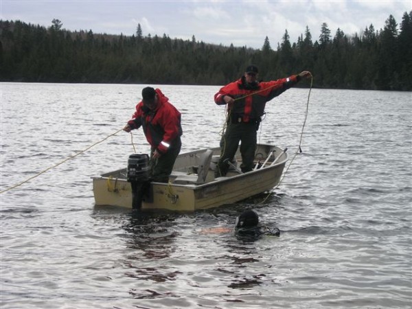 Cpl. Mike Joy (left) and Wardens Bruce Loring and Mike Pierre (in the water) during Tuesday's Blake Lake search. Cpl. Mike Joy (left) and Wardens Bruce Loring and Mike Pierre (in the water) during Tuesday's Blake Lake search.