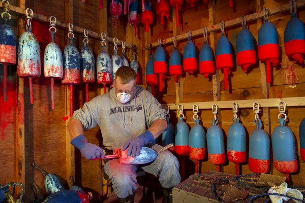 Lobsterman Kendall Delano sands last year's paint off lobster buoys he's painting in his workshop in Friendship, Maine, Thursday, May 10, 2012. Lobsterman Kendall Delano sands last year's paint off lobster buoys he's painting in his workshop in Friendship, Maine, Thursday, May 10, 2012.