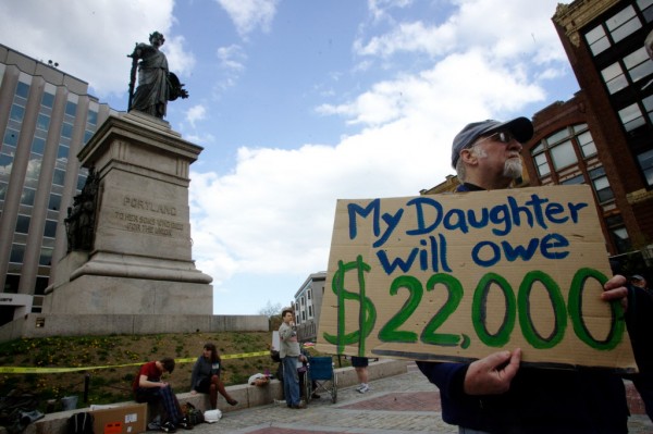Val Hart holds a sign in Portland's Monument Square Wednesday April 25, 2012 during an Occupy movement's protest of the student loan crisis. Hart says his daughter will bear over $22,000 in student loans even after he chips in and she receives scholarships. Val Hart holds a sign in Portland's Monument Square Wednesday April 25, 2012 during an Occupy movement's protest of the student loan crisis. Hart says his daughter will bear over $22,000 in student loans even after he chips in and she receives scholarships.