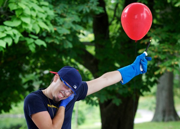 Zachary Chopchinski, vice president of the University of Southern Maine Chemistry Club, waits for the boom as he lights a balloon filled with oxygen and hydrogen during a science show for children in Portland's Deering Oaks Park on Thursday, July 26, 2012. Zachary Chopchinski, vice president of the University of Southern Maine Chemistry Club, waits for the boom as he lights a balloon filled with oxygen and hydrogen during a science show for children in Portland's Deering Oaks Park on Thursday, July 26, 2012.