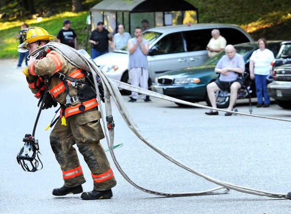 A Lewiton firefighter drags hose into Blake Street Towers during Monday's fire. A Lewiton firefighter drags hose into Blake Street Towers during Monday's fire.