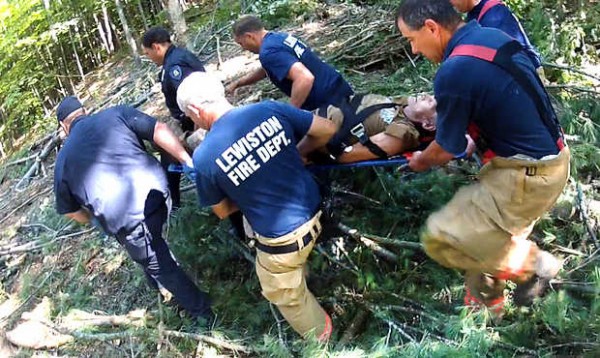 United Ambulance personnel and Lewiston police and firefighters carry a logger through the woods off River Road in Lewiston on Wednesday morning, July 11, 2012 after he was pinned beneath his skidder. United Ambulance personnel and Lewiston police and firefighters carry a logger through the woods off River Road in Lewiston on Wednesday morning, July 11, 2012 after he was pinned beneath his skidder.