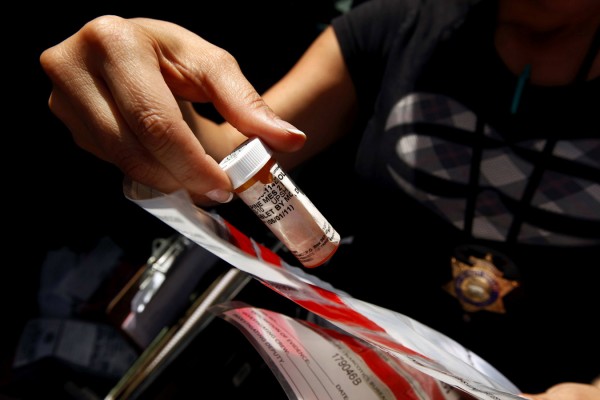Deputy Grace Schmidt, member of the Los Angeles County Health Authority Law Enforcement Task Force, books evidence from an undercover prescription drug sting operation on a downtown Los Angeles street. Deputy Grace Schmidt, member of the Los Angeles County Health Authority Law Enforcement Task Force, books evidence from an undercover prescription drug sting operation on a downtown Los Angeles street.