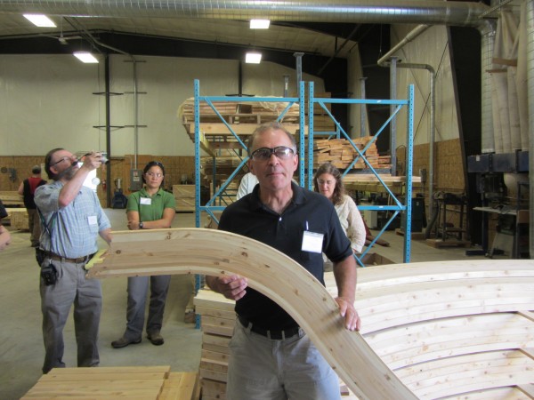 Don Protheroe, plant manager for CedarWorks, shows off a curved piece of cedar that will go into one of the company's play sets. Don Protheroe, plant manager for CedarWorks, shows off a curved piece of cedar that will go into one of the company's play sets.