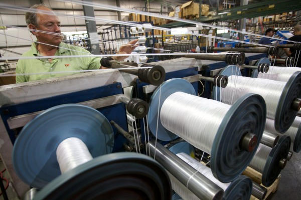 Tom Yale, owner of Yale Cordage, checks up on the machines weaving synthetic line in his Saco factory. Tom Yale, owner of Yale Cordage, checks up on the machines weaving synthetic line in his Saco factory.