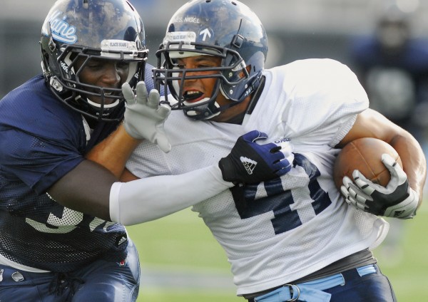 UMaine's Malik Walker (34) takes down teammate Nigel Jones (41) during a intrasquad scrimmage Tuesday afternoon, Aug. 28, 2012 on Morse Field in Orono. UMaine's Malik Walker (34) takes down teammate Nigel Jones (41) during a intrasquad scrimmage Tuesday afternoon, Aug. 28, 2012 on Morse Field in Orono.