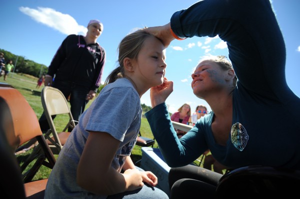 Volunteer Maegan Sanders (right) of Bangor Youth Cheering applies face paint to Kelsey Moulton, 7, as her mom Shannon Eberhart (in background, on left) looks on. The Bangor Housing Authority held its end-of-summer block party at Downeast Elementary School Wednesday, Aug. 29, 2012. Volunteer Maegan Sanders (right) of Bangor Youth Cheering applies face paint to Kelsey Moulton, 7, as her mom Shannon Eberhart (in background, on left) looks on. The Bangor Housing Authority held its end-of-summer block party at Downeast Elementary School Wednesday, Aug. 29, 2012.
