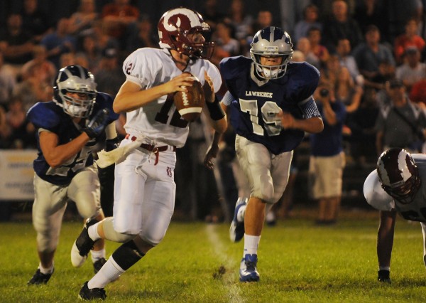 Bangor quarterback Carl Farnham looks for a receiver while being pursued by Lawrence defenders Jake Doolan (25) and Trevor Hamblet (79) during 2nd quarter action on Friday, September 7, 2012, at Lawrence. Bangor quarterback Carl Farnham looks for a receiver while being pursued by Lawrence defenders Jake Doolan (25) and Trevor Hamblet (79) during 2nd quarter action on Friday, September 7, 2012, at Lawrence.