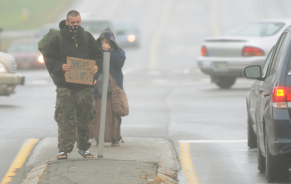 A man and his girfriend panhandle along Hogan Road in Bangor on Wednesday, Sept. 5, 2012, in a rain storm. They claimed to be from North Carolina and were headed to Eastport to scatter his recently deceased mother's ashes. The van they were sharing with 4 others and a dog was parked at the Bangor Mall as they worked the traffic along Hogan Road. A man and his girfriend panhandle along Hogan Road in Bangor on Wednesday, Sept. 5, 2012, in a rain storm. They claimed to be from North Carolina and were headed to Eastport to scatter his recently deceased mother's ashes. The van they were sharing with 4 others and a dog was parked at the Bangor Mall as they worked the traffic along Hogan Road.