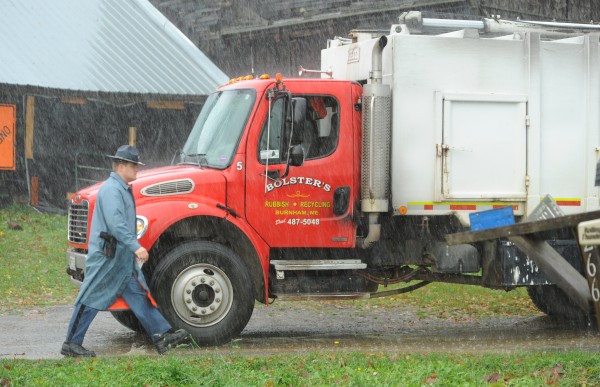 Maine State Police Trooper Christopher Cookson walks past a garbage truck owned by Bolster's of Burnham while investigating reports that the driver was shot at by a resident of a farm on Bowden Road in Corinna on Tuesday, Oct. 30, 2012. Maine State Police Trooper Christopher Cookson walks past a garbage truck owned by Bolster's of Burnham while investigating reports that the driver was shot at by a resident of a farm on Bowden Road in Corinna on Tuesday, Oct. 30, 2012.