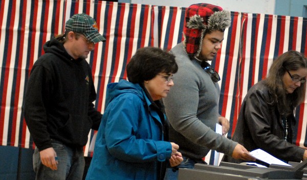 First time voter Michael Beale (center), 21, feeds his ballot into the ballot box at the Brewer Auditorium Tuesday morning. Happy about his first voting experience, Beale said "I feel like I have a say in it all. It's only one vote, but it's something." First time voter Michael Beale (center), 21, feeds his ballot into the ballot box at the Brewer Auditorium Tuesday morning. Happy about his first voting experience, Beale said "I feel like I have a say in it all. It's only one vote, but it's something."