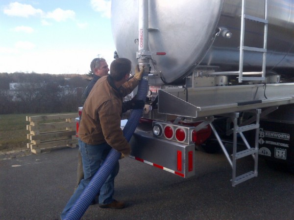 Trans-Tech project engineer Tom Fick (left) assists Maine Energy Systems driver Daryl Burgman with disconnecting the wood pellet delivery system tube from the back of a new a 15-ton capacity pneumatic truck that can deliver a ton of pellets in about four minutes. Trans-Tech lead fabricator Matt Mower and quality control manager John Bennett also assisted but are not pictured. Trans-Tech project engineer Tom Fick (left) assists Maine Energy Systems driver Daryl Burgman with disconnecting the wood pellet delivery system tube from the back of a new a 15-ton capacity pneumatic truck that can deliver a ton of pellets in about four minutes. Trans-Tech lead fabricator Matt Mower and quality control manager John Bennett also assisted but are not pictured.