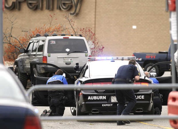 Auburn police officers take cover behind a police cruiser surrounding a suspect inside a Jeep Cherokee during a standoff at Shaw's Plaza in Auburn on Monday. Auburn police officers take cover behind a police cruiser surrounding a suspect inside a Jeep Cherokee during a standoff at Shaw's Plaza in Auburn on Monday.