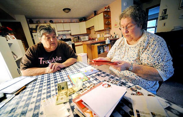 Marge Chaplin, left, helps out her neighbor, Betty Lugner, who has Parkinson's disease, by writing out Lugner's Christmas cards Monday in Auburn. On Friday, Lugner was the victim of a phone scam saying her grandson would be jailed in Mexico if she didn't send cash. Marge Chaplin, left, helps out her neighbor, Betty Lugner, who has Parkinson's disease, by writing out Lugner's Christmas cards Monday in Auburn. On Friday, Lugner was the victim of a phone scam saying her grandson would be jailed in Mexico if she didn't send cash.