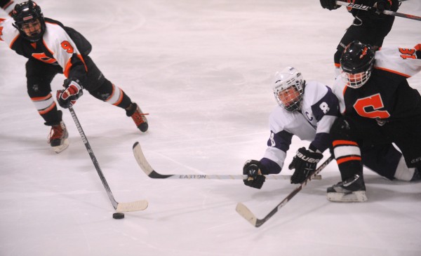 Skowhegan's Anthony James Paul (left) and Ann-Marie Provencal (right) battle for the puck with Hampden's Cooper Antone during the game in Brewer on Wednesday, Jan. 9, 2013. Skowhegan's Anthony James Paul (left) and Ann-Marie Provencal (right) battle for the puck with Hampden's Cooper Antone during the game in Brewer on Wednesday, Jan. 9, 2013.