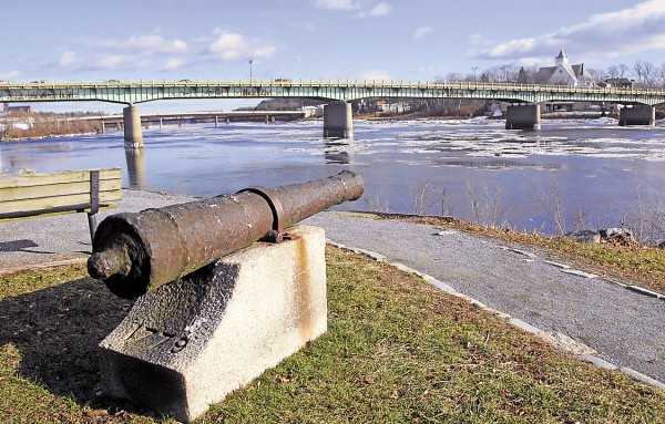 From the Bangor shore, a corroded cannon lost in the Penobscot River in 1779 points toward the Joshua Chamberlain Bridge and Brewer shore (right). The light green paint that covers the bridge has flaked away in many places, exposing the underlying steel to corrosion. In a project set to begin this spring, a contractor hired by the Maine Department of Transportation will remove the bridge’s existing lead-based paint and cover the steel with a primer and two coats of a non-lead-based paint. During the project, traffic will be restricted to one lane, with vehicles traveling only from Brewer to Bangor. From the Bangor shore, a corroded cannon lost in the Penobscot River in 1779 points toward the Joshua Chamberlain Bridge and Brewer shore (right). The light green paint that covers the bridge has flaked away in many places, exposing the underlying steel to corrosion. In a project set to begin this spring, a contractor hired by the Maine Department of Transportation will remove the bridge’s existing lead-based paint and cover the steel with a primer and two coats of a non-lead-based paint. During the project, traffic will be restricted to one lane, with vehicles traveling only from Brewer to Bangor.