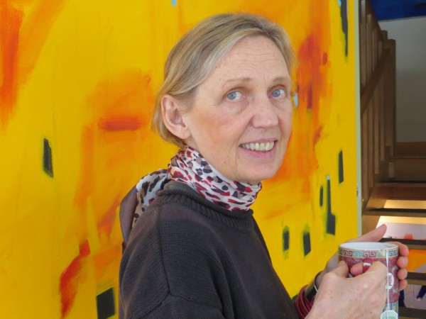 Gail Page, holding a cup of tea, stands in front of a large canvas she painted with one of her favorite "positive energy colors." Gail Page, holding a cup of tea, stands in front of a large canvas she painted with one of her favorite "positive energy colors."
