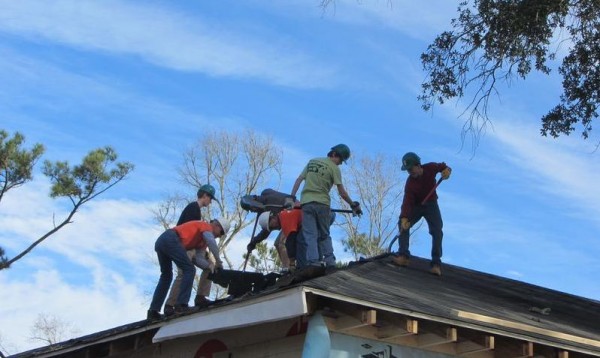 Falmouth students and members of the "Tiger Team," a group of retired men who work with Habitat for Humanity on a regular basis, strip shingles to prepare for replacing the roof on David McCulloch's Mississippi home. Falmouth students and members of the "Tiger Team," a group of retired men who work with Habitat for Humanity on a regular basis, strip shingles to prepare for replacing the roof on David McCulloch's Mississippi home.