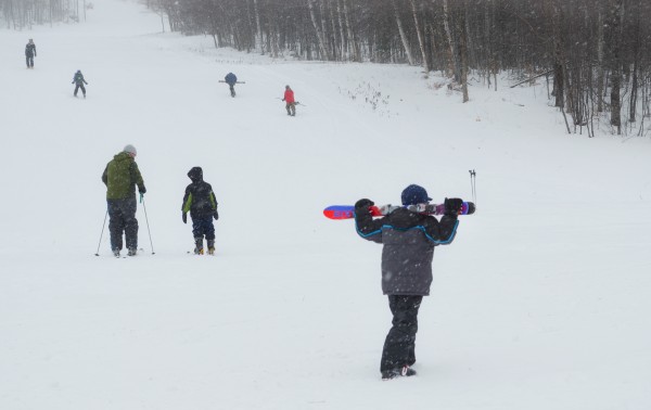A boy carries his skis behind his head as he walks along the base of the hill at Big Squaw Mountain Ski Resort on Big Moose Mountain on Sunday, Feb. 17, 2013. The mountain hosted the third week of its Mogul Mites learn-to-ski program. A boy carries his skis behind his head as he walks along the base of the hill at Big Squaw Mountain Ski Resort on Big Moose Mountain on Sunday, Feb. 17, 2013. The mountain hosted the third week of its Mogul Mites learn-to-ski program.