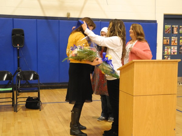 Kimberly Buckheit, the principal of Troy Howard Middle School in Belfast, receives a sash and a bouquet of flowers from Emily Harriman, 13, the student council president during a ceremony to honor Buckheit's selection as Maine's Middle Level Principal of the Year by the Maine Principals' Association. Kimberly Buckheit, the principal of Troy Howard Middle School in Belfast, receives a sash and a bouquet of flowers from Emily Harriman, 13, the student council president during a ceremony to honor Buckheit's selection as Maine's Middle Level Principal of the Year by the Maine Principals' Association.