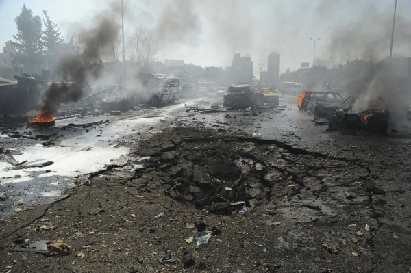 Vehicles burn near a crater on a road after an explosion at central Damascus February 21, 2013, in this handout photograph released by Syria's national news agency SANA. Vehicles burn near a crater on a road after an explosion at central Damascus February 21, 2013, in this handout photograph released by Syria's national news agency SANA.