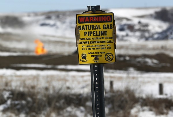 A warning sign for a natural gas pipeline is seen at an oil pump site outside of Williston, N.D. A warning sign for a natural gas pipeline is seen at an oil pump site outside of Williston, N.D.