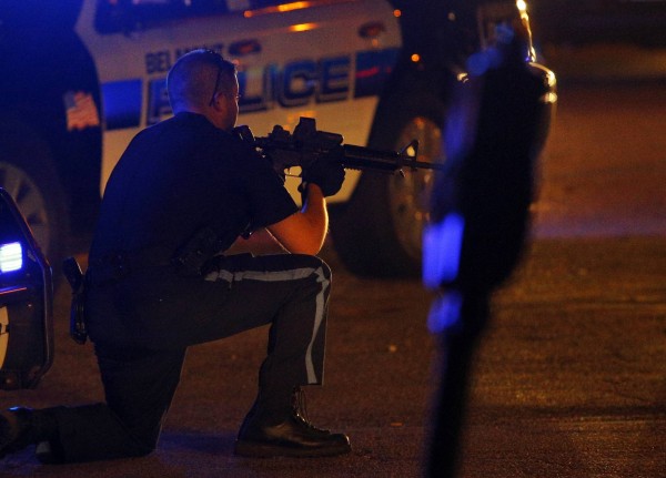 A police officer points his rifle at a man on the ground in Watertown, Mass. A police officer points his rifle at a man on the ground in Watertown, Mass.
