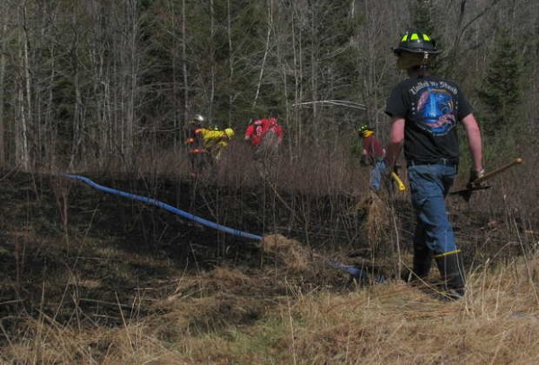 River Valley area firefighters work Friday afternoon to ensure that a woods fire that burned an acre behind a home at 19 Holman Road in Dixfield is completely out. River Valley area firefighters work Friday afternoon to ensure that a woods fire that burned an acre behind a home at 19 Holman Road in Dixfield is completely out.