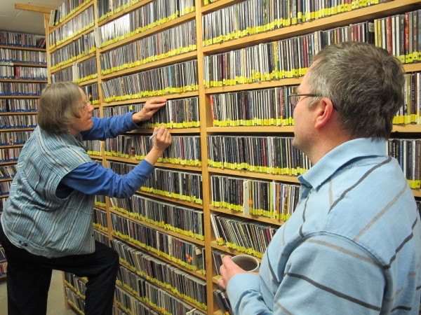 Pat Fowler files CDs at the WERU on-air library, while station manager Matt Murphy looks on. Pat Fowler files CDs at the WERU on-air library, while station manager Matt Murphy looks on.