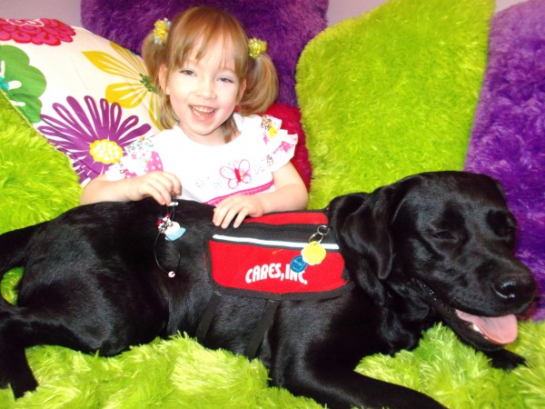 Faith McNally, 5, the adopted daughter of Bruce and Beverly McNally of Island Falls, suffers from spina bifida and life-threatening seizures. She poses here with her black Labrador retriever, Dandy, who serves as an assistance dog to help her cope with her seizures. Faith McNally, 5, the adopted daughter of Bruce and Beverly McNally of Island Falls, suffers from spina bifida and life-threatening seizures. She poses here with her black Labrador retriever, Dandy, who serves as an assistance dog to help her cope with her seizures.