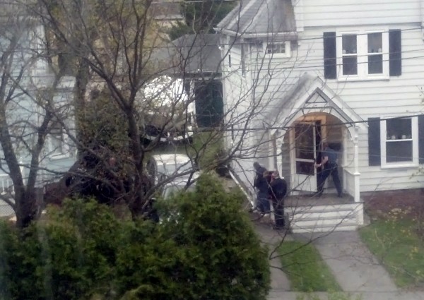 In this neighbor's view from across the street, law enforcement agents look around the corner of a house where Boston Marathon bombing suspect Dzhokhar Tsarnaev was believed to be hiding in Watertown, Massachusetts, April 19, 2013. In this neighbor's view from across the street, law enforcement agents look around the corner of a house where Boston Marathon bombing suspect Dzhokhar Tsarnaev was believed to be hiding in Watertown, Massachusetts, April 19, 2013.