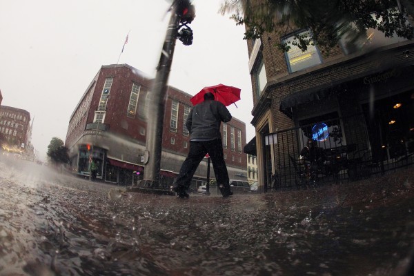 A pedestrian walks crosses Hammond Street during a downpour on Friday. A pedestrian walks crosses Hammond Street during a downpour on Friday.