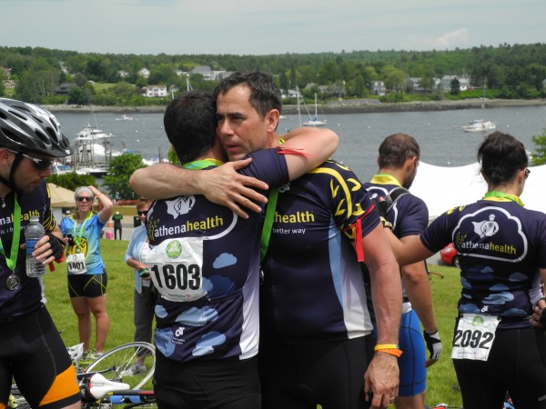 David Tassoni of athenahealth embraces a teammate after finishing the three-day, 180-mile Trek Across Maine on Sunday afternoon. David LeClair, a 23-year-old athenahealth employee from Watertown, Mass., was killed Friday morning shortly after the beginning of the fundraising event in a collision with a tractor-trailer truck. "I'm so proud of being part of this whole group," Tassoni said at the trek's emotional conclusion. David Tassoni of athenahealth embraces a teammate after finishing the three-day, 180-mile Trek Across Maine on Sunday afternoon. David LeClair, a 23-year-old athenahealth employee from Watertown, Mass., was killed Friday morning shortly after the beginning of the fundraising event in a collision with a tractor-trailer truck. "I'm so proud of being part of this whole group," Tassoni said at the trek's emotional conclusion.