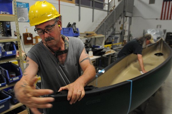 John Sibley puts trim on a canoe at the end of the assembly line at Johnson Outdoors in Old Town on Monday. John Sibley puts trim on a canoe at the end of the assembly line at Johnson Outdoors in Old Town on Monday.