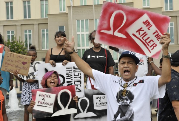 Demonstrators hold signs outside Seminole County Court where George Zimmerman's second-degree murder trial is being deliberated by jurors in Sanford, Fla., on Saturday, July 13, 2013. Demonstrators hold signs outside Seminole County Court where George Zimmerman's second-degree murder trial is being deliberated by jurors in Sanford, Fla., on Saturday, July 13, 2013.