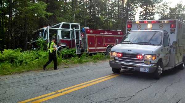 A Penobscot County Sheriff's deputy surveys the damage to a Carmel Fire Department rescue pumper that veered off Route 69 on the evening of July 7, 2013, on its way to a call. A Penobscot County Sheriff's deputy surveys the damage to a Carmel Fire Department rescue pumper that veered off Route 69 on the evening of July 7, 2013, on its way to a call.