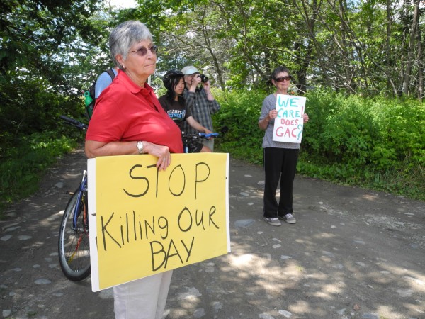 Environmental activists carrying signs listen Tuesday afternoon as Ron Huber of Friends of Penobscot Bay talked about possible contamination of the shoreline from a succession of fertilizer and chemical companies located in the same Kidder Point site for nearly 100 years. Environmental activists carrying signs listen Tuesday afternoon as Ron Huber of Friends of Penobscot Bay talked about possible contamination of the shoreline from a succession of fertilizer and chemical companies located in the same Kidder Point site for nearly 100 years.
