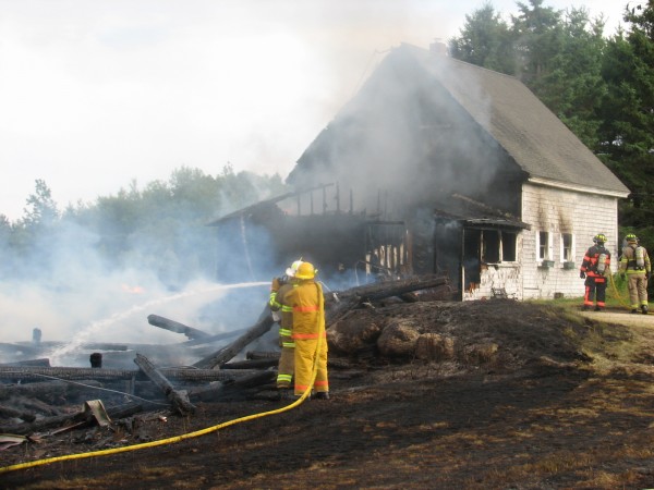 Firefighters spray water on the burning remains of a barn that caught fire Thursday, July 18, 2013, on Webb Pond Road in Eastbrook. The cause of the fire, which spread to and destroyed a nearby house, has not been determined, according to firefighters. Seven Hancock County towns sent firefighters to help put out the blaze. Firefighters spray water on the burning remains of a barn that caught fire Thursday, July 18, 2013, on Webb Pond Road in Eastbrook. The cause of the fire, which spread to and destroyed a nearby house, has not been determined, according to firefighters. Seven Hancock County towns sent firefighters to help put out the blaze.
