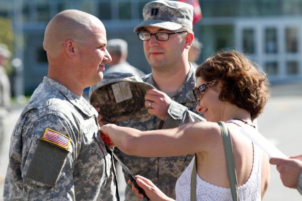 Carrie Mancini uses a knife to remove her husband's old rank insignia during a promotion ceremony on the University of Southern Maine campus Saturday morning. Captain Mark Mancini is deploying with the 133rd Engineer Battalion next week. Carrie Mancini uses a knife to remove her husband's old rank insignia during a promotion ceremony on the University of Southern Maine campus Saturday morning. Captain Mark Mancini is deploying with the 133rd Engineer Battalion next week.