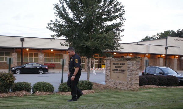A policeman walks in front of McNair Discovery Learning Academy after a shooting incident in Decatur, Georgia, August 20, 2013. Police arrested a 20-year-old man on Tuesday for opening fire with an AK-47 inside an elementary school in the Atlanta suburbs, forcing the evacuation of 800 students who were all reunited with their parents without injury, officials said. A policeman walks in front of McNair Discovery Learning Academy after a shooting incident in Decatur, Georgia, August 20, 2013. Police arrested a 20-year-old man on Tuesday for opening fire with an AK-47 inside an elementary school in the Atlanta suburbs, forcing the evacuation of 800 students who were all reunited with their parents without injury, officials said.