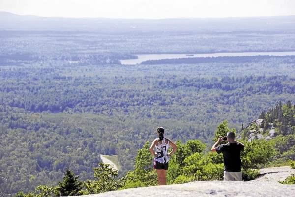 While exploring the summit of Chick Hill in Clifton, two hikers enjoy the westerly view. Among the visible landmarks are a curve on Route 9 (left) and Chemo Pond (above). While exploring the summit of Chick Hill in Clifton, two hikers enjoy the westerly view. Among the visible landmarks are a curve on Route 9 (left) and Chemo Pond (above).